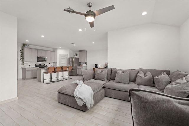 living room featuring vaulted ceiling and ceiling fan