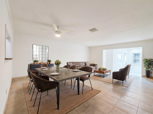 tiled dining space with ceiling fan