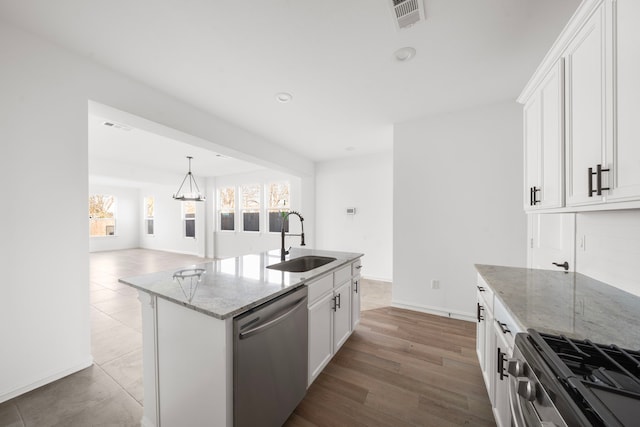 kitchen with sink, light stone counters, a center island with sink, appliances with stainless steel finishes, and white cabinets