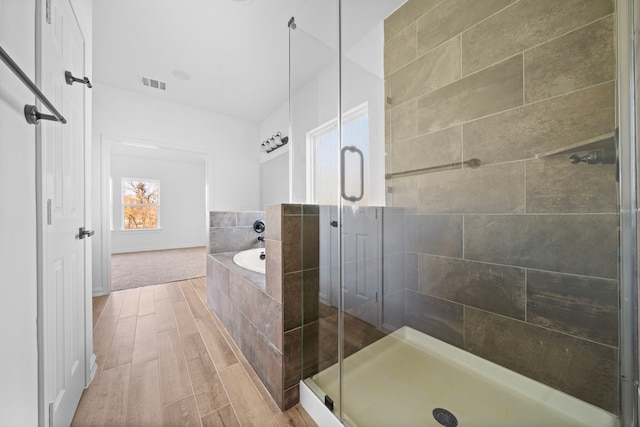 bathroom featuring separate shower and tub and hardwood / wood-style floors