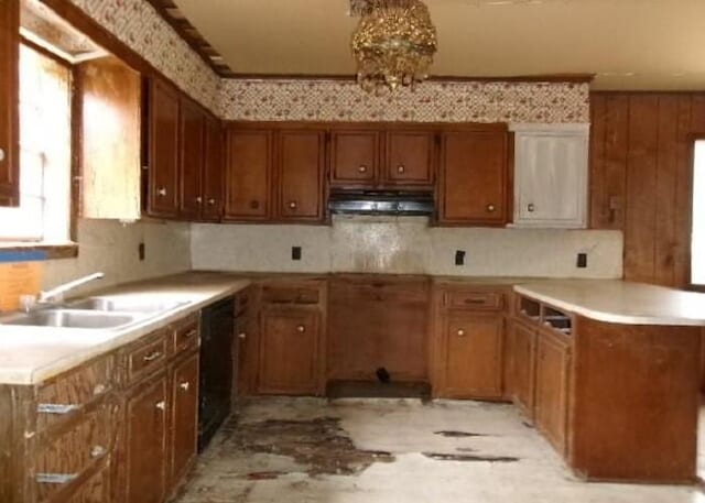 kitchen featuring sink, tasteful backsplash, an inviting chandelier, dishwasher, and exhaust hood