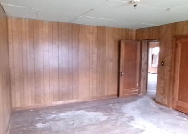 empty room featuring wood walls