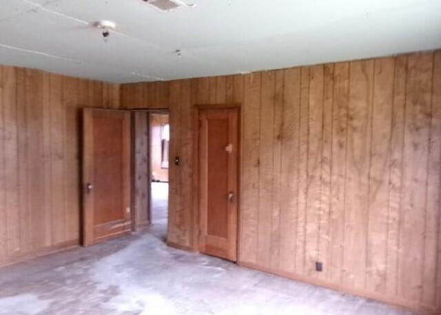 empty room featuring wood walls