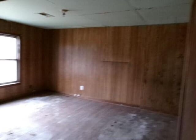 spare room featuring wood walls