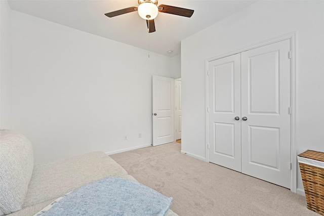 bedroom featuring light carpet, a closet, and ceiling fan