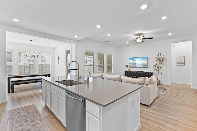 kitchen with sink, decorative light fixtures, dishwasher, an island with sink, and white cabinets