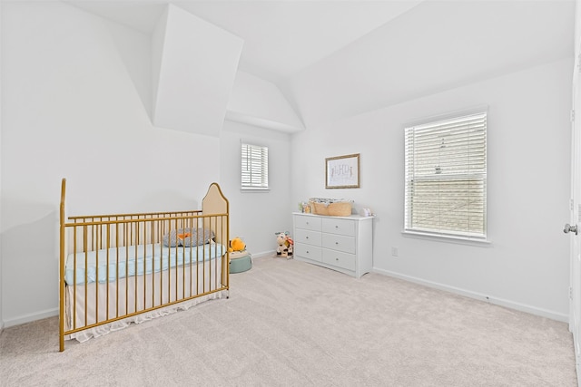 bedroom with lofted ceiling, light carpet, and a nursery area