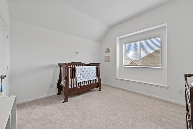 bedroom featuring vaulted ceiling, a nursery area, and light colored carpet