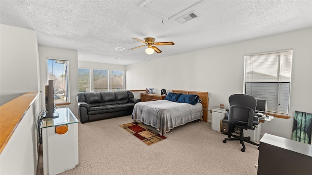 carpeted bedroom with a textured ceiling and ceiling fan