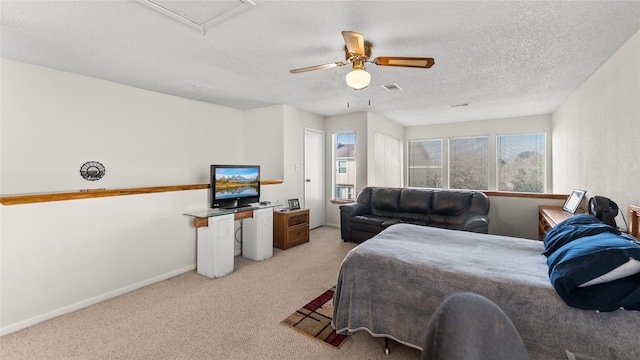 carpeted bedroom with ceiling fan and a textured ceiling