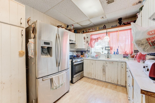 kitchen with sink, a paneled ceiling, light hardwood / wood-style flooring, stainless steel appliances, and white cabinets