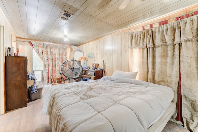 bedroom featuring wooden ceiling, wood walls, and light wood-type flooring