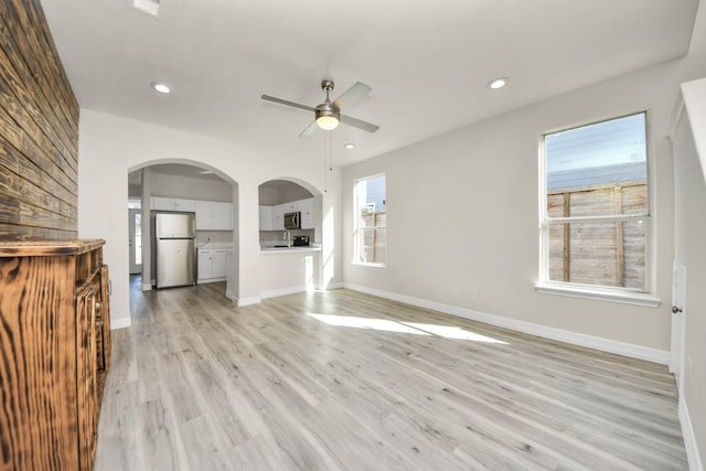 unfurnished living room with ceiling fan and light hardwood / wood-style flooring