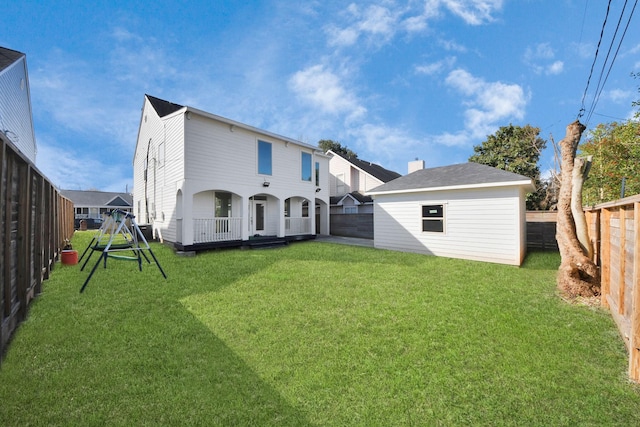 rear view of property with a yard and an outdoor structure