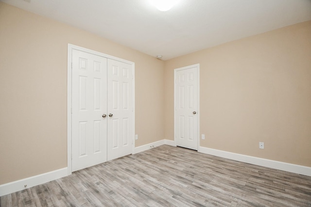 unfurnished bedroom featuring light hardwood / wood-style floors and a closet