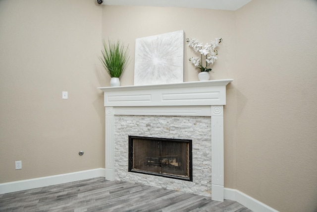 room details with a stone fireplace and hardwood / wood-style floors