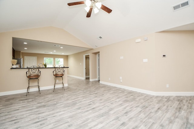 unfurnished living room with light hardwood / wood-style flooring, ceiling fan, and vaulted ceiling