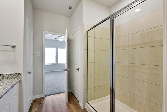 bathroom featuring hardwood / wood-style flooring, vanity, an enclosed shower, and ceiling fan