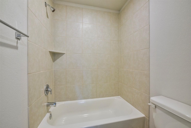 bathroom with tiled shower / bath combo and toilet