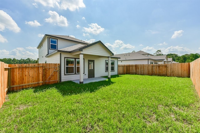 rear view of house featuring a patio and a lawn