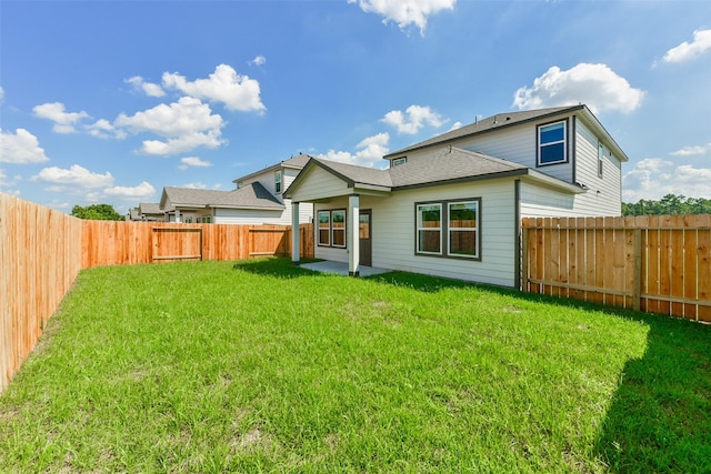 back of house with a patio area and a lawn