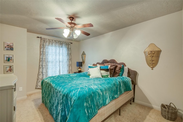 bedroom featuring ceiling fan, light carpet, and a textured ceiling