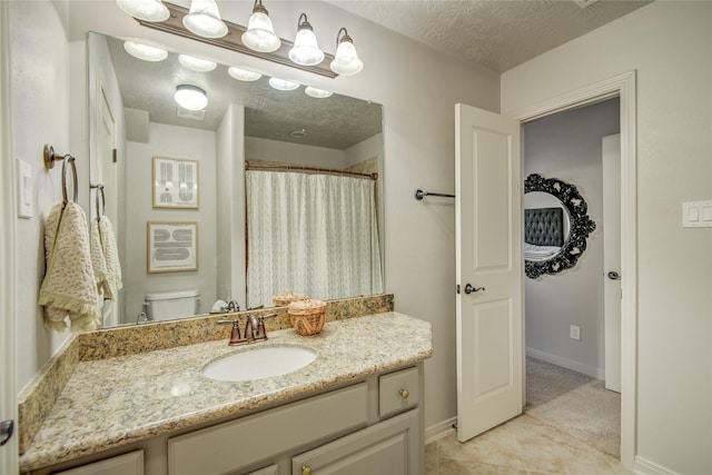 bathroom with vanity, tile patterned floors, toilet, and a textured ceiling