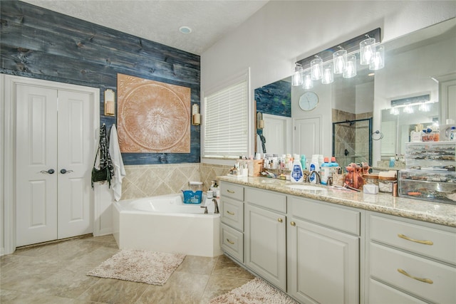 bathroom with vanity, a textured ceiling, and plus walk in shower