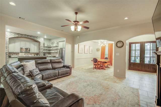 living room with crown molding, light tile patterned floors, ceiling fan, and french doors