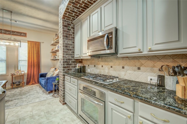 kitchen featuring stainless steel appliances, decorative light fixtures, decorative backsplash, and dark stone counters