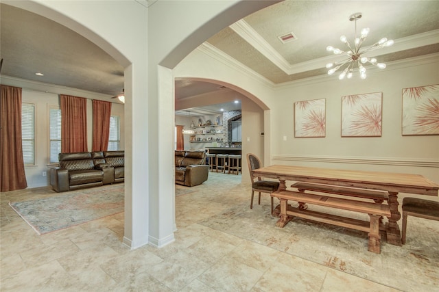 dining room with a notable chandelier, crown molding, and a raised ceiling