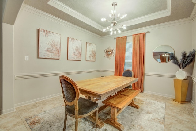 dining area with an inviting chandelier, ornamental molding, a tray ceiling, and light tile patterned floors