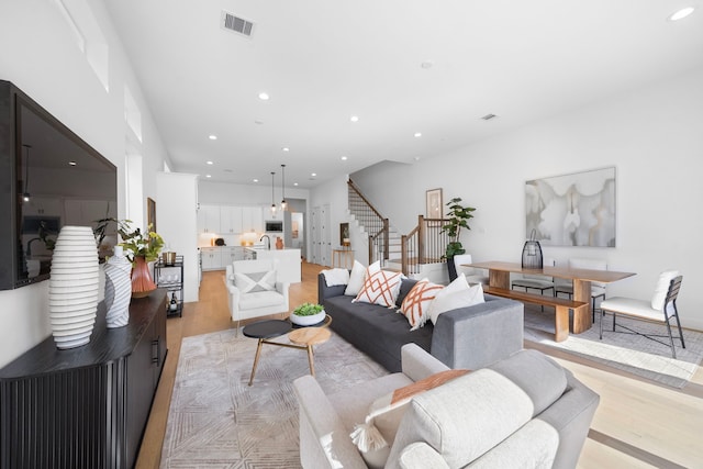 living room with sink and light hardwood / wood-style flooring