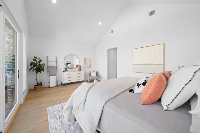 bedroom with high vaulted ceiling and light hardwood / wood-style floors