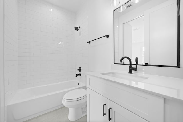 full bathroom featuring tile patterned flooring, tiled shower / bath, vanity, and toilet