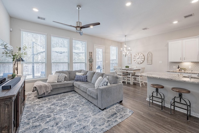 living room with dark hardwood / wood-style flooring and ceiling fan