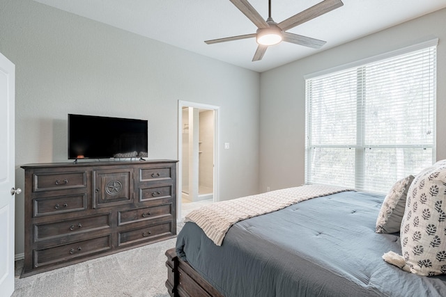 carpeted bedroom featuring ceiling fan and ensuite bath