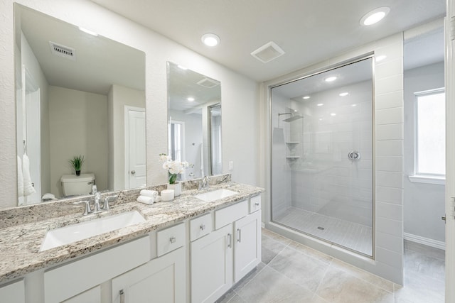 bathroom featuring tile patterned floors, vanity, toilet, and a shower with door