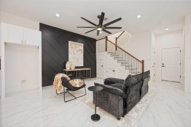 living room with ceiling fan and wood walls