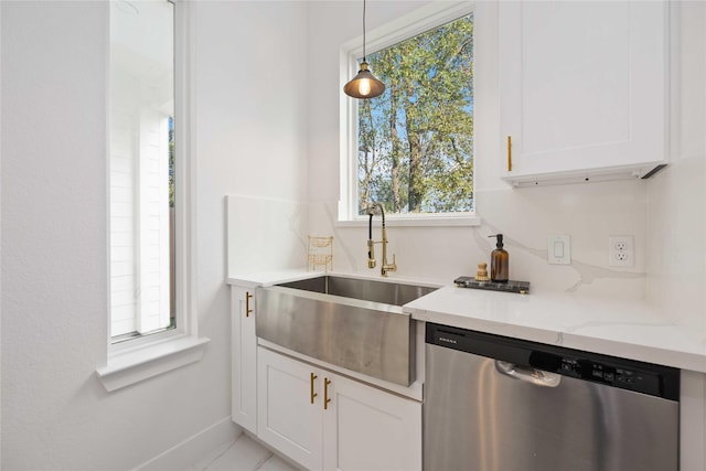 kitchen with hanging light fixtures, sink, stainless steel dishwasher, and white cabinets