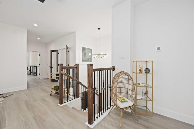 stairway featuring hardwood / wood-style floors and an inviting chandelier