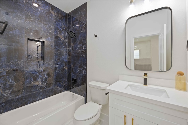 full bathroom featuring vanity, tiled shower / bath, and toilet