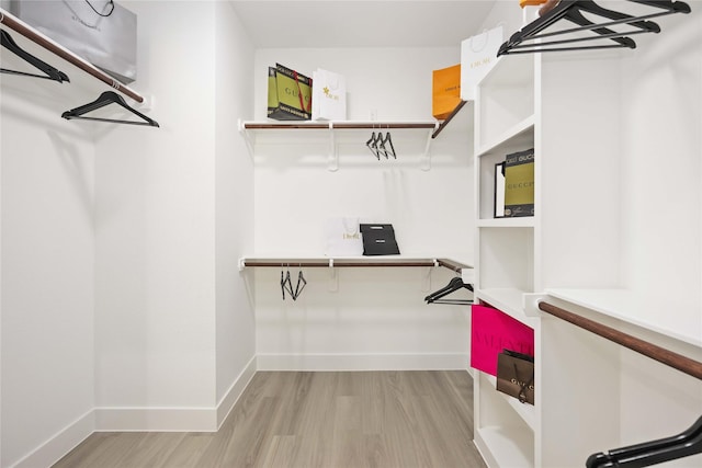 walk in closet with light hardwood / wood-style flooring