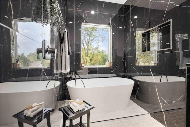 bathroom with a tub and tile walls