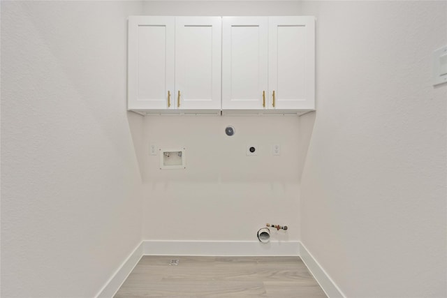 washroom featuring gas dryer hookup, cabinets, light hardwood / wood-style flooring, washer hookup, and hookup for an electric dryer