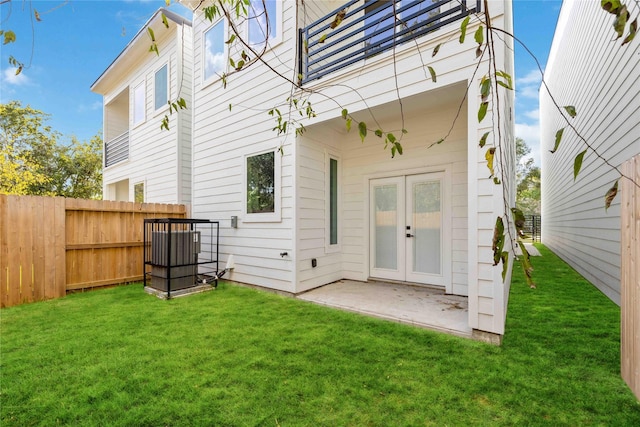 rear view of house featuring a lawn, french doors, and a patio area