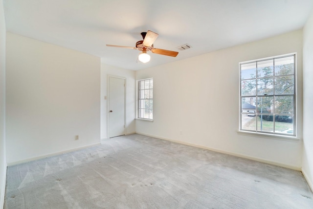 carpeted empty room featuring plenty of natural light and ceiling fan