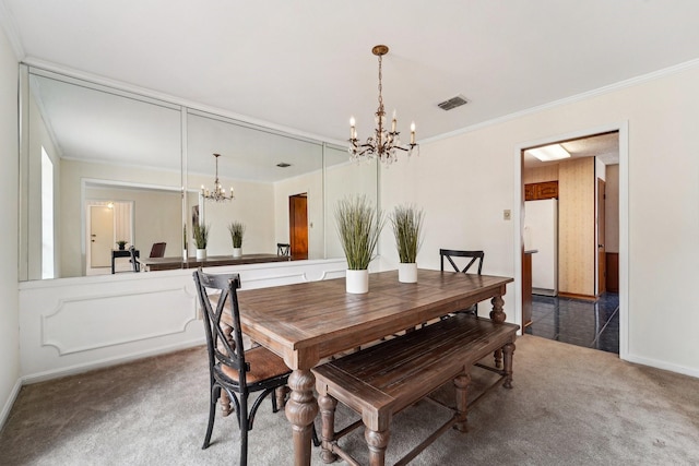 carpeted dining room featuring a notable chandelier and crown molding