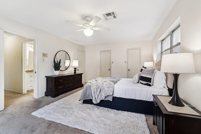 carpeted bedroom with ceiling fan and ensuite bathroom