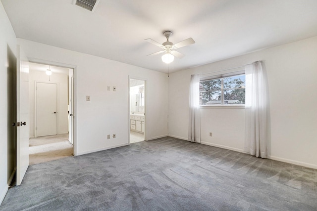 unfurnished bedroom featuring ensuite bathroom, light colored carpet, and ceiling fan